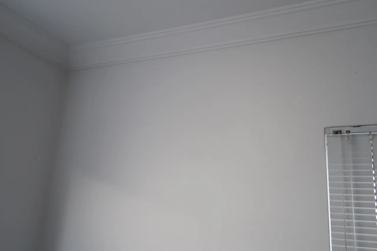Same bedroom wall patched, sanded and painted with no holes visible