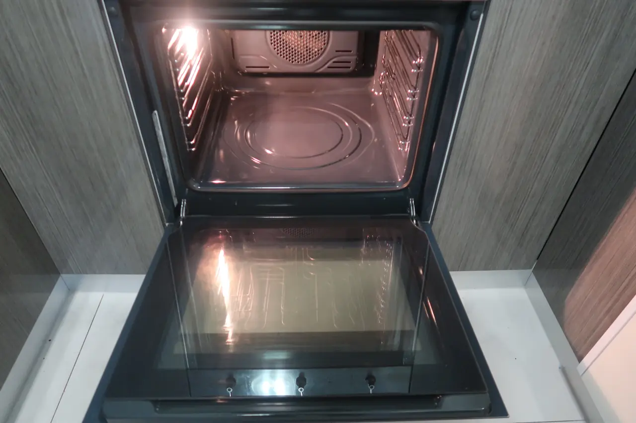 Same oven interior after a deep clean, racks and floor spotless
