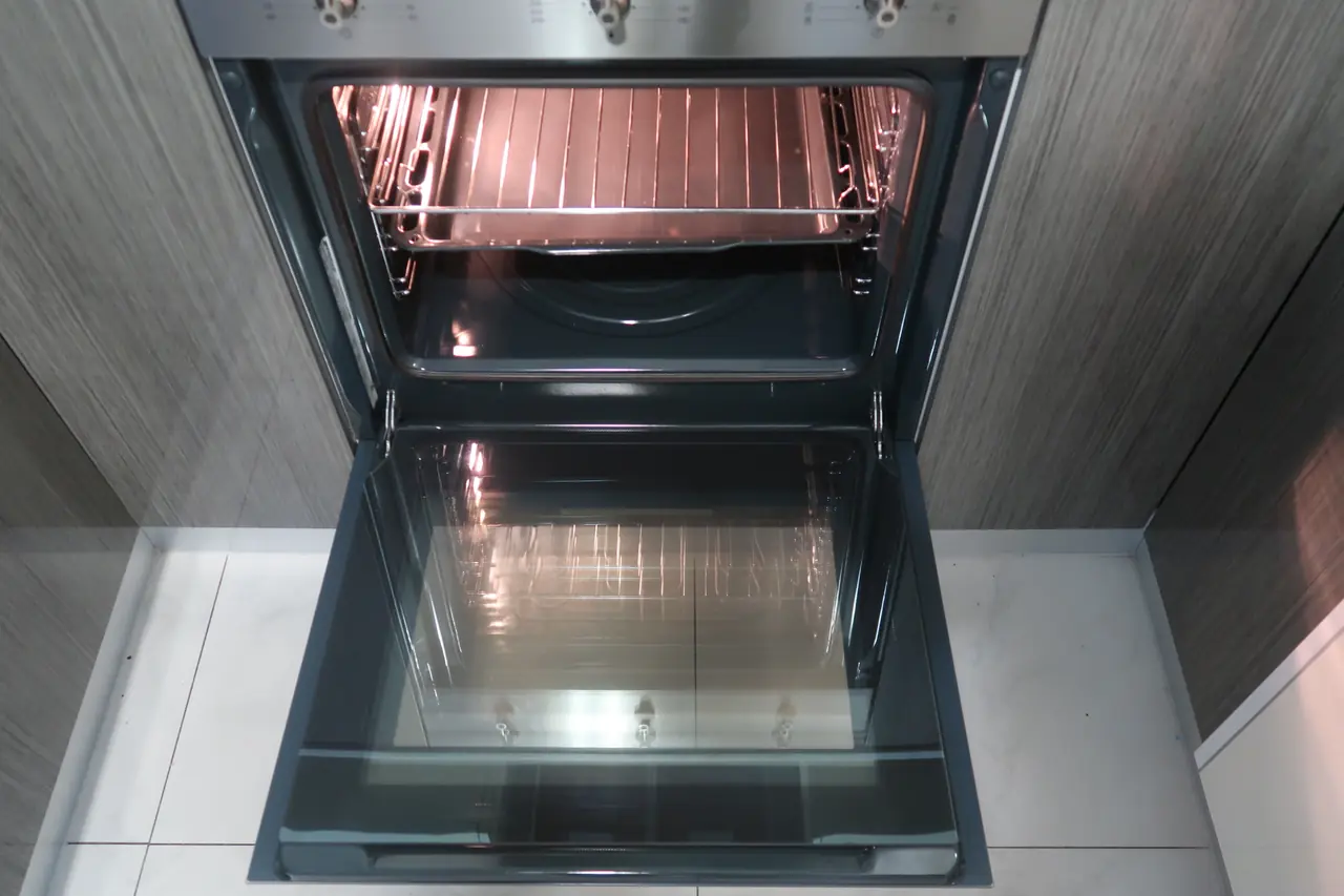 Same oven interior after a deep clean, tray and racks spotless
