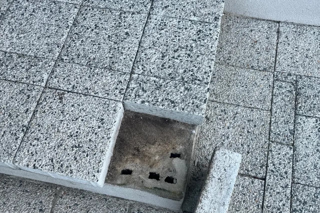 Damaged, loose corner paver tile on an exterior entry step