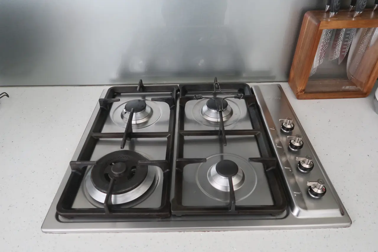 Same gas stovetop with grates and burner caps back on, cleaned and reseated