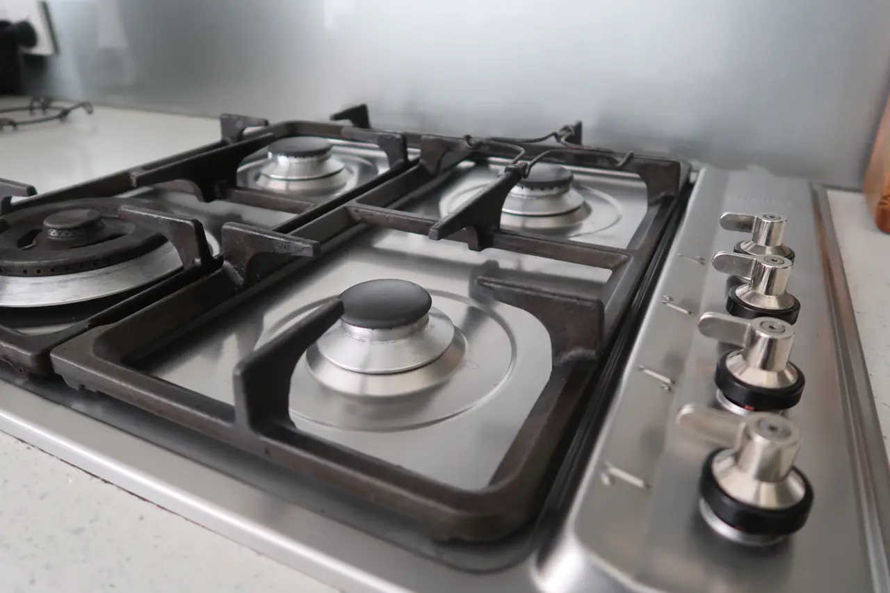 Same stovetop reassembled and degreased, burner caps clean